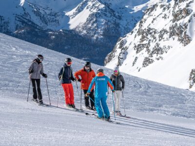 Oxygene male Ski instructor teaching adult ski lessons group in Val Thorens